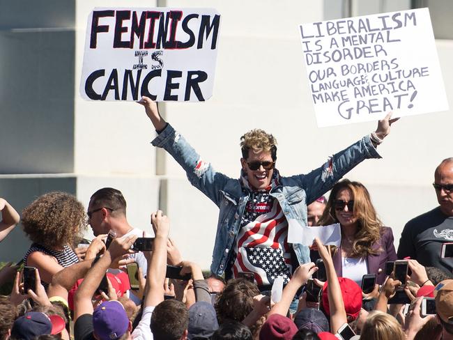 Conservative commentator Milo Yiannopoulos holds up signs to a crowd of supporters at the University of California, Berkeley campus last September.