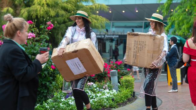 Staff arrive at Flemington in wet weather gear. Picture: Jay Town