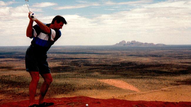 Sam Newman using a one-iron to hit a ball off Uluru