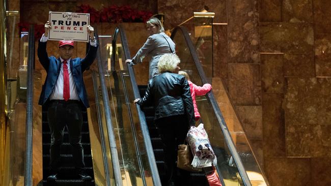 A supporter of Donald Trump rides the escalator at Trump Tower. Picture: Drew Angerer/Getty Images/AFP