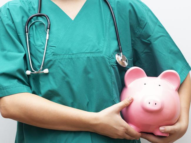 Doctor with piggy bank in hand representing medical costs