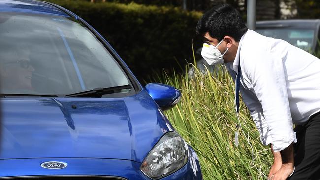 A security guard speaks with a driver outside Anglicare Newmarch House agedcare home in Kingswood, near Penrith, NSW. Picture: AAP