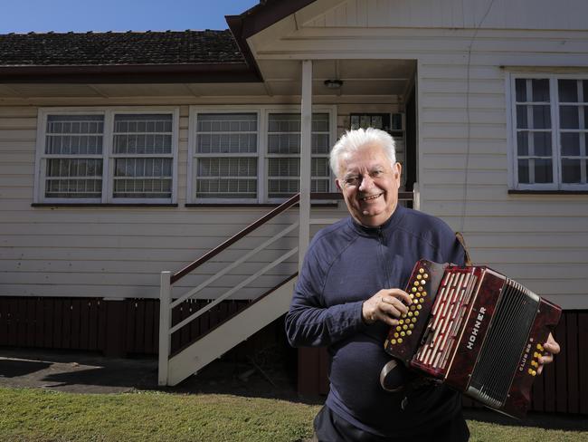 Henry Palaszczuk with his dad's squeeze box out side his old home at Inala. Picture: Mark Cranitch.