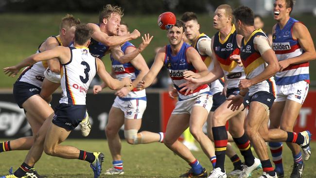 Central District’s Travis Schiller gets a handball away under pressure against Adelaide. Picture: AAP Image/Dean Martin