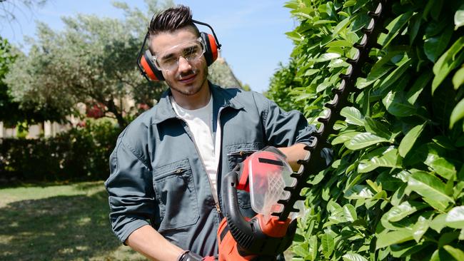 CAREERS: One side hustle is no longer enough to make ends meet, with a growing number of Australians requiring several income streams to pay their mortgage and put food on the table.  Young man gardener trimming hedge. Picture: iStock