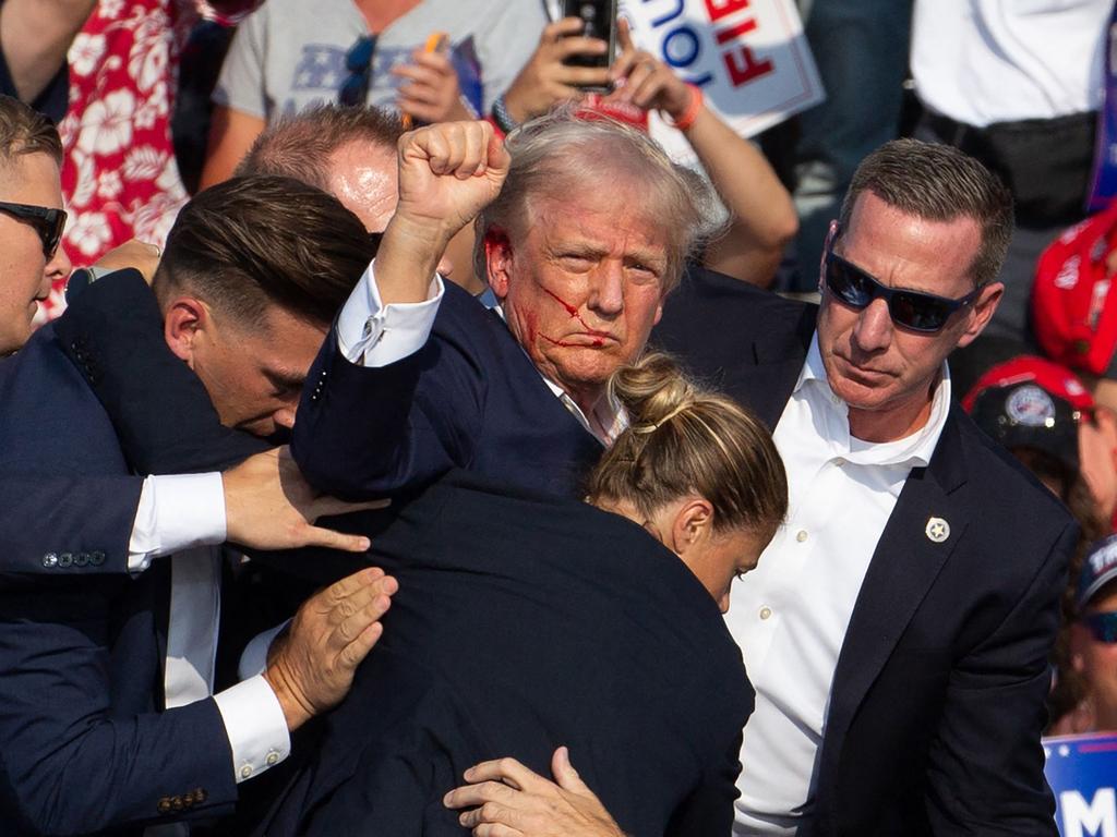 Republican candidate Donald Trump is seen with blood on his face surrounded by secret service agents as he is taken off the stage after being shot at a campaign event at Butler Farm Show Inc. in Butler, Pennsylvania, July 13, 2024. Picture: AFP.