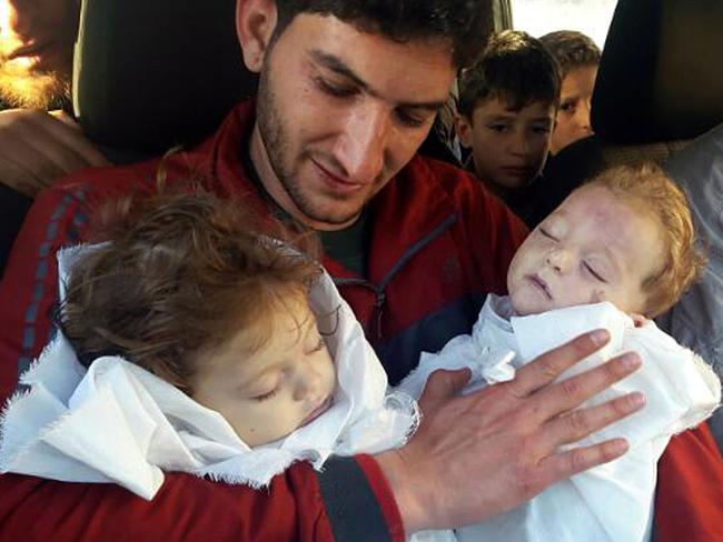 Abdul-Hamid Alyousef, 29, holds his twin babies who were killed during a suspected chemical weapons attack.