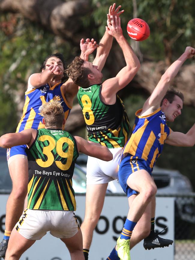 Dromana’s Beau Cosson flies in between two Somerville opponents, while Tiger Dane Leyden-Kozikas awaits a crumb. Picture: David Crosling