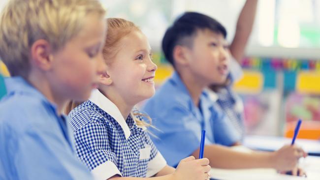 Generic photo of happy students in their classroom wearing their school uniform