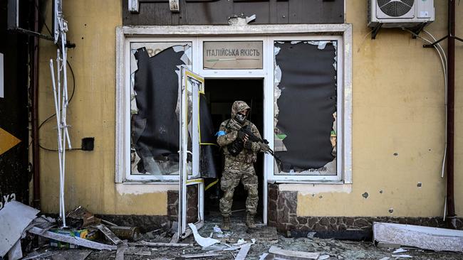 A Ukrainian serviceman leaves a building damaged by shelling in Kyiv on Saturday. Picture: AFP