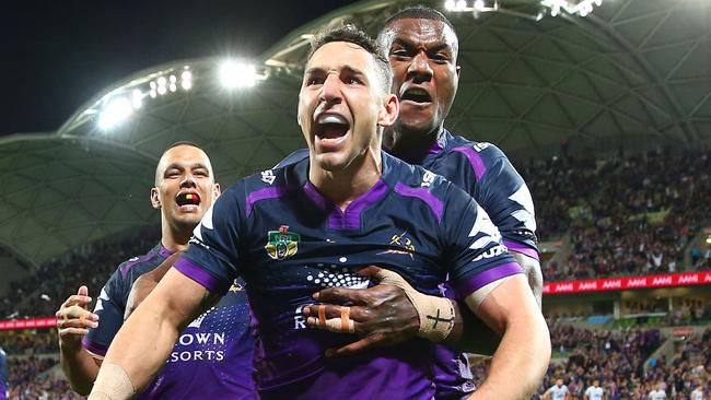 Billy Slater of the Storm is congratulated by Suliasi Vunivalu and his teammates after scoring a try.