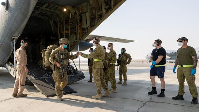 Commander Joint Task Force 633 Air Commodore David Paddison CSC, welcomes soldiers from the 1st Battalion, Royal Australian Regiment, as they disembark a Royal Australian Air Force C-130J Hercules aircraft at Australia's main operating base in the Middle East region, after their flight from Kabul, Afghanistan.