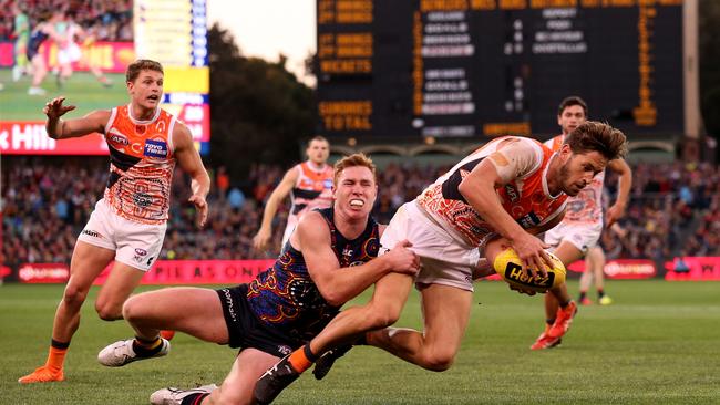 Tom Lynch brings down GWS gun Callan Ward at Adelaide Oval. The Crows leader is without a contract next year. Picture: James Elsby/AFL Media/Getty Images