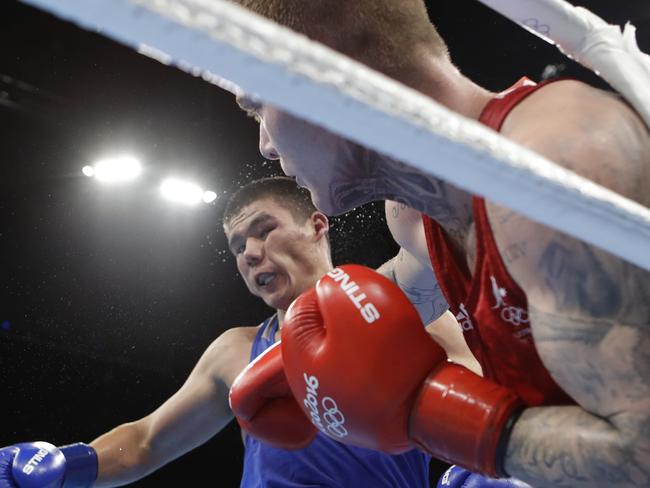 Uzbekistan's Bektemir Melikuziev, left, is punched as he fights Australia's Daniel Jason Lewis during a men's middleweight 75-kg preliminary boxing match at the 2016 Summer Olympics in Rio de Janeiro, Brazil, Friday, Aug. 12, 2016. (AP Photo/Frank Franklin II)