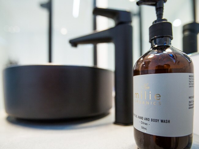 Black accents and local toiletries in the modern bathroom. Picture: Greg Power