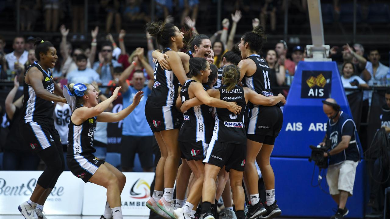 Canberra Capitals players celebrate after winning game three of the WNBL grand final series.