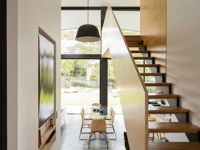 Open-tread staircase leading to an upper-level sitting area is a quiet nod to 1960s architecture.