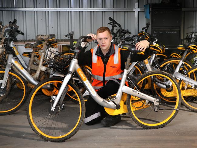 An impound officer with some of the Obikes fished from the Yarra or vandalised at the City Impound Yard. Picture: David Caird