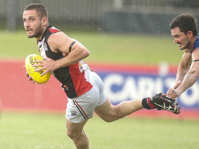 James Tsitas (ball) and Simon Bates in the NTFL Round 13 match  Wanderers v Southern Districts at TIO Stadium.Picture GLENN CAMPBELL