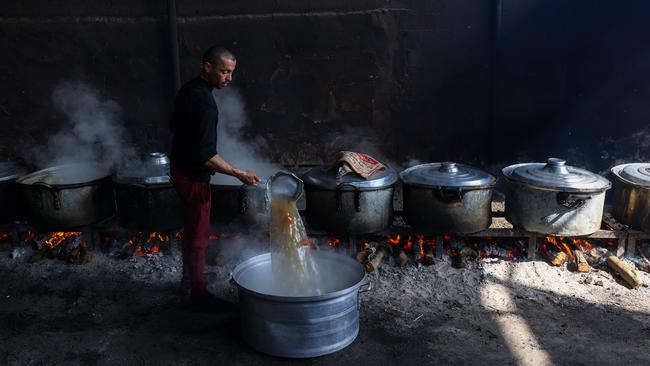 Palestinians prepare meals for the UN shelter to be distributed to the displaced in Rafah, on the southern Gaza Strip. Picture: AFP