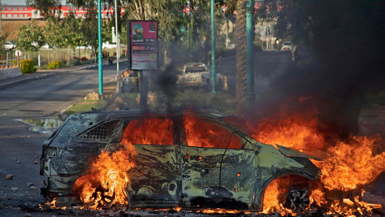 An Israeli police car burns after an Arab Israeli demonstration following the funeral of Mousa Hassouna in the central city of Lod. Picture: AFP