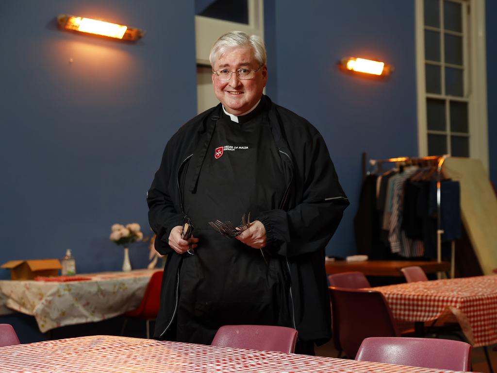 Father Anthony Robbie setting tables at Order of Malta's soup kitchen. The kitchen is one the many services helping the homeless across Sydney. Picture: Richard Dobson