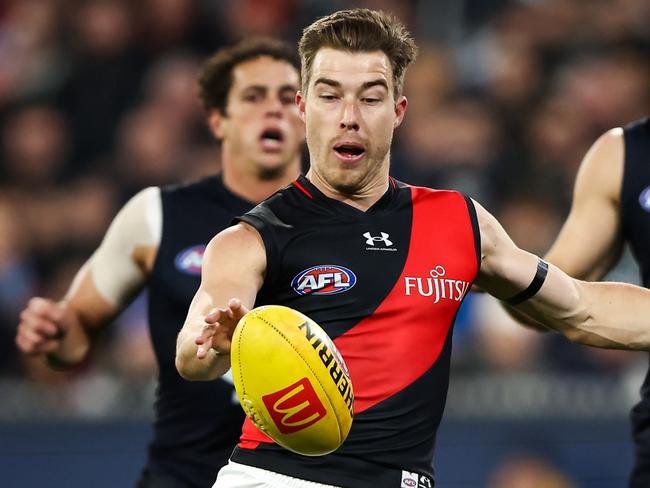 MELBOURNE, AUSTRALIA - JUNE 11: Zach Merrett of the Bombers kicks the ball during the 2023 AFL Round 13 match between the Carlton Blues and the Essendon Bombers at the Melbourne Cricket Ground on June 11, 2023 in Melbourne, Australia. (Photo by Dylan Burns/AFL Photos via Getty Images)