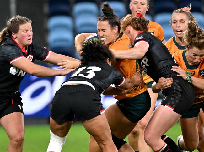 Australia's Maya Stewart (C) is tackled by Canada's Fancy Bermudez (2nd L) during the a Womenâs Rugby Union match between Australia and Canada at the Alliance Stadium in Sydney on May 11, 2024. (Photo by Saeed KHAN / AFP) / -- IMAGE RESTRICTED TO EDITORIAL USE - STRICTLY NO COMMERCIAL USE --