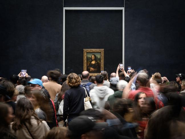 (FILES) Visitors take picture of the painting "La Joconde" The Mona Lisa by Italian artist Leonardo Da Vinci on display in a gallery at The Louvre Museum in Paris, on April 20, 2023. President of the Louvre Laurence Des Cars announced on April 27, 2024 that she had a discussion with the Ministry of Culture to improve the exhibition conditions of the famous Mona Lisa by Leonardo da Vinci at the Louvre Museum, and possibly present it in a separate room. (Photo by LOIC VENANCE / AFP)