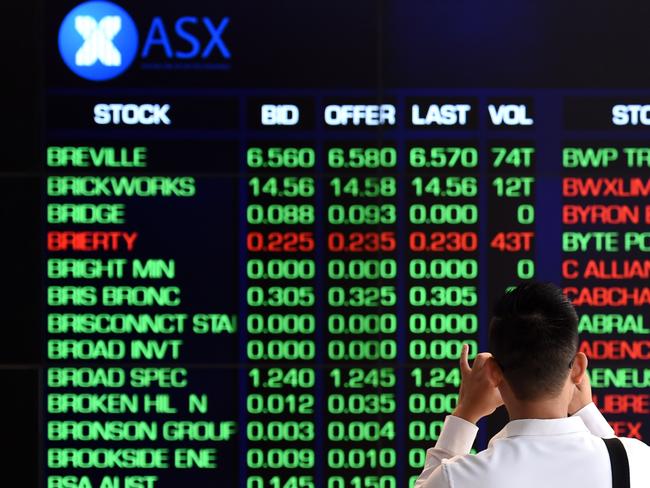 A man takes a photograph of an information board showing share prices at the Australian Stock Exchange in Sydney on Monday, Dec. 14, 2015. The ASX market has tumbled at the open, with falls across the board following a 2pct slide on Wall Street last Friday. (AAP Image/Paul Miller) NO ARCHIVING