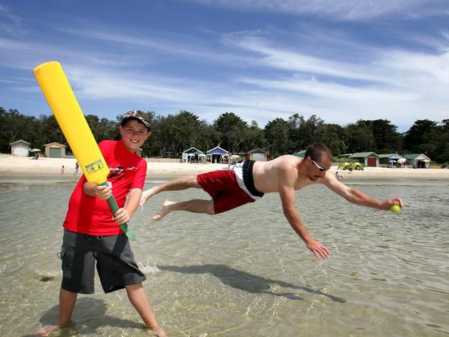 William Spence, 9, and Alistair Bucanan, 33, play beach cricket at Rosebud.