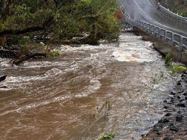 Floodwaters rage near a new bridge just outside between Nambour and Yandina after heavy rain on the Sunshine Coast.