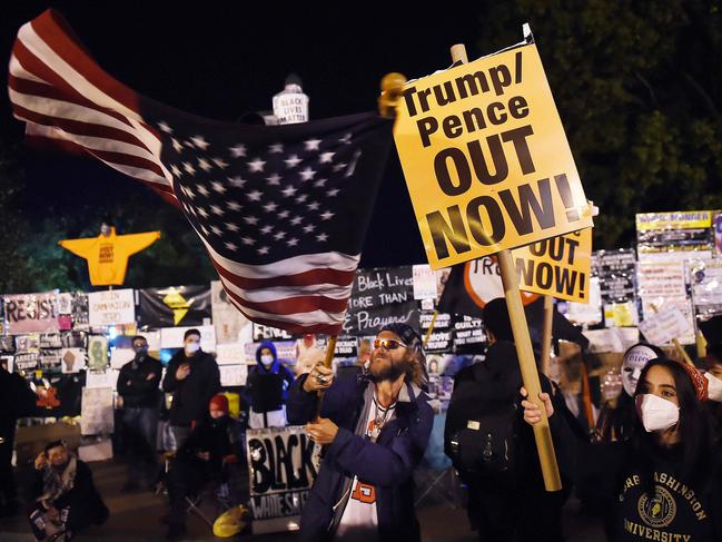 A Trump supporter waves a US flag in the face of demonstrators at Black Lives Matter plaza across from the White House. Picture: AFP