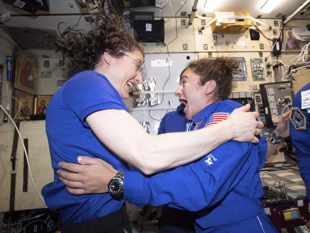 Jessica Meir and Christina Koch, left, greet each other after Meir's arrival on the International Space Station. Picture: NASA via AP