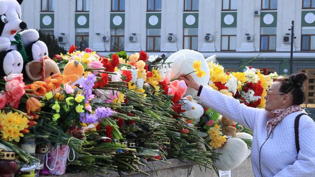 A woman lays flowers at a makeshift memorial in Simferopol, Crimea, as Russia observes a national day of mourning after a massacre in the Crocus City Hall that killed more than 130 people. Picture: AFP