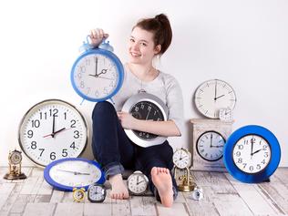 a girl sets many clocks to daylight saving time