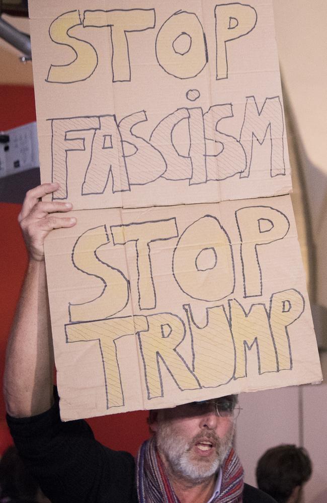 An anti-Trump protester in Switzerland carries a sign saying: ‘STOP FASCISM STOP TRUMP’. Picture: Anthony Anex/Keystone via AP