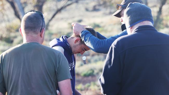 Liam, 15 receives his dog tags during extraction at the conclusion of Operation Flinders. Picture: Simon Cross