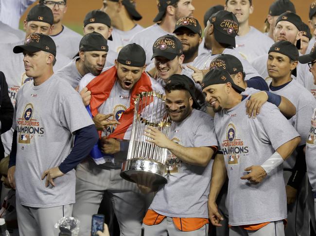 FILE - In this Nov. 1, 2017 file photo, the Houston Astros celebrate with the trophy after their win against the Los Angeles Dodgers in Game 7 of baseball's World Series in Los Angeles. The Los Angeles City Council wants Major League Baseball to strip the Houston Astros and Boston Red Sox of their World Series titles and award the trophies to the Dodgers. The resolution was introduced Tuesday, Jan. 21, 2020, after it was revealed that the Astros used a system by then-coach Alex Cora in 2017 to tip off batters on what pitch was to be thrown.  (AP Photo/Alex Gallardo, File)