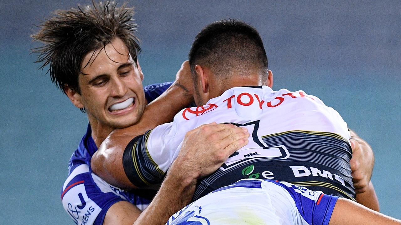Valentine Holmes of the Cowboys is tackled by Lachlan Lewis.