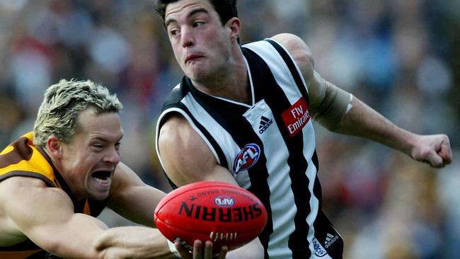 New Monbulk coach Andrew Williams gets a handball away against Hawthorn’s Kris Barlow during his time with Collingwood.