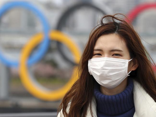 A woman wearing a mask walks near the Olympics' mark in Odaiba, Tokyo on February 22, 2020, amid the outbreak of a new coronavirus in Japan. ( The Yomiuri Shimbun via AP Images )