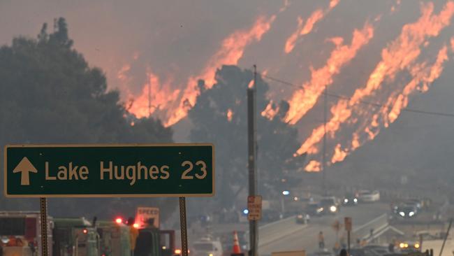 Flames from the Hughes Fire burn a hillside in Castaic, a northwestern part of Los Angeles County, California, on January 22, 2025. A new wildfire erupted north of Los Angeles on January 22, exploding in size and sparking thousands of evacuation orders in a region already staggering from the effects of huge blazes. Ferocious flames were devouring hillsides near Castaic Lake, spreading rapidly to cover 5,000 acres (2,000 hectares) in just over two hours. The fire was being fanned by strong, dry Santa Ana winds that were racing through the area, pushing a vast pall of smoke and embers ahead of the flames. Evacuations were ordered for 19,000 people all around the lake, which sits around 35 miles north of Los Angeles, and close to the city of Santa Clarita. (Photo by Robyn Beck / AFP)