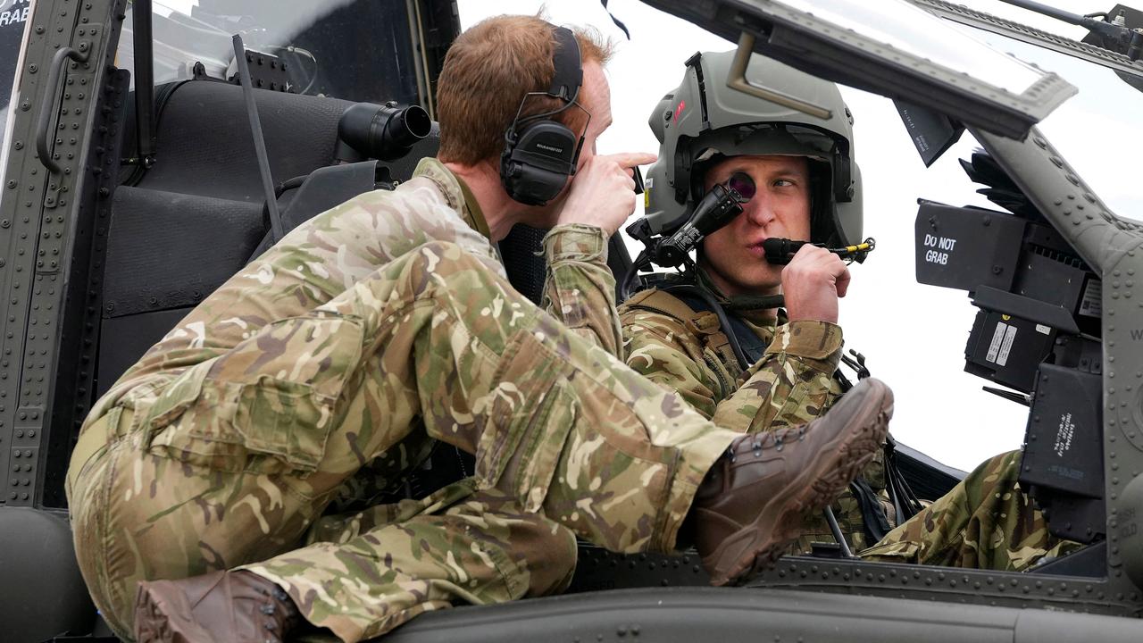 Britain's Prince William, Prince of Wales (R) receives advice as he sits in the cockpit of an Apache helicopter at the Army Aviation Centre in Middle Wallop, England, on Monday, May 13, 2024. Britain's King Charles III officially handed over the role of Colonel-in-Chief of the Army Air Corps to his son Britain's Prince William, Prince of Wales. (Photo by Kin Cheung / POOL / AFP)