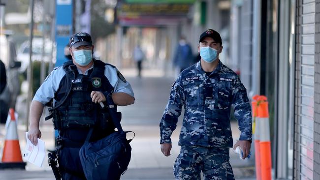 An ADF personal and a police officer pictured in the Fairfield CBD. The ADF are supporting NSW Police with operational management of Sydney's Lockdown. Picture: NCA NewsWire / Damian Shaw