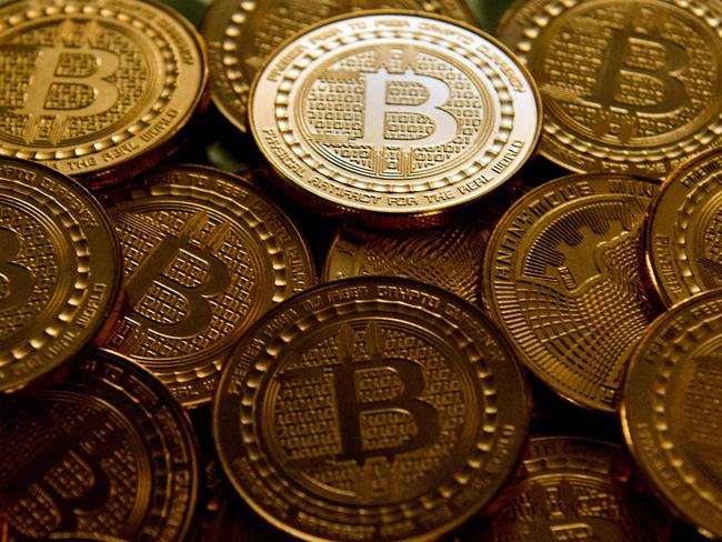 (FILES):  This file photo taken in Washington, DC, on May 1, 2014 shows bitcoin medals.  Bitcoin burst out of the shadows in 2017, seducing Wall Street and individual investors alike even though many still struggle to understand precisely what it is. The cryptocurrency's rise is also pushing regulators to consider taking action after years of simply urging caution.  / AFP PHOTO / Karen BLEIER