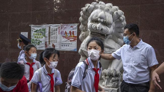 Students wear protective masks as they arrive for class on the first day of the new school year in Beijing. Picture: Getty Images