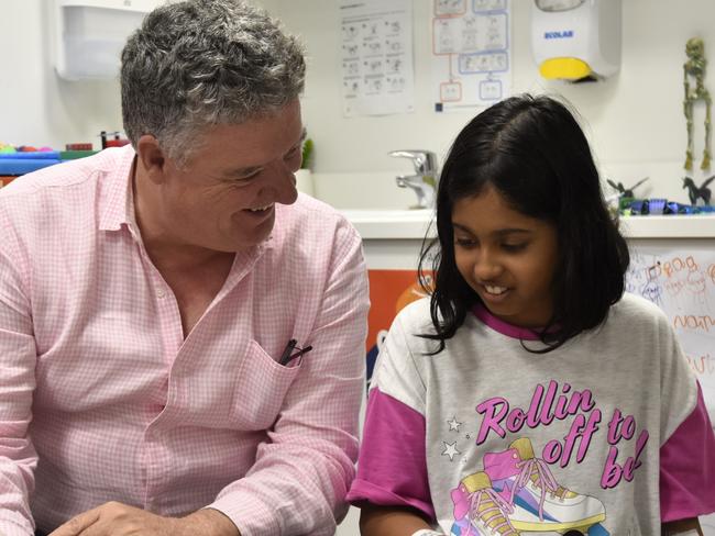 Education Minister Mark Monaghan reads to a Royal Darwin Hospital school student. Picture: SIerra Haigh