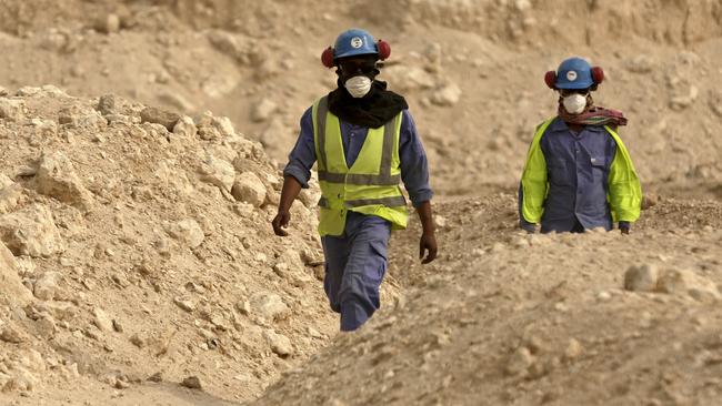 Workers walk back to the Al-Wakra Stadium worksite being built for the 2022 World Cup, in Doha, Qatar.