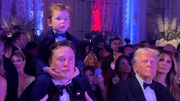 Elon Musk, with his son, stands alongside president-elect Donald Trump and Melania Trump during Tuesday's New Year's Eve party at Mar-a-Lago.